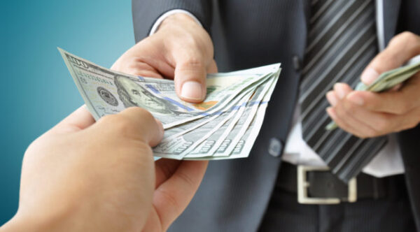 Two people exchanging cash Two people exchanging cash