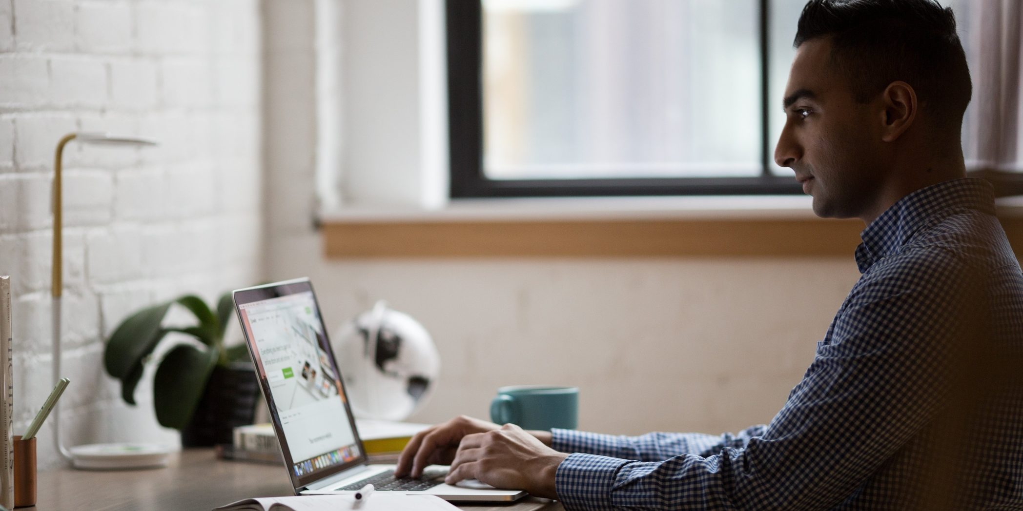 A man working on his laptop A man sitting and working on his laptop