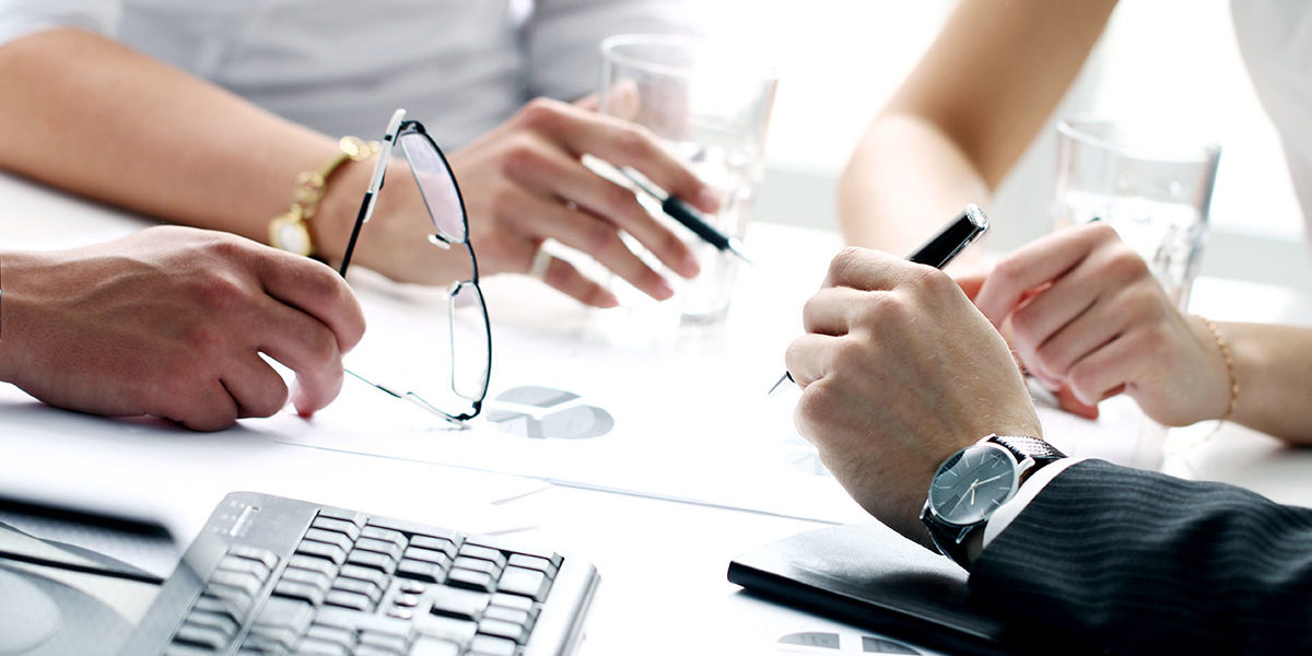 Four pairs of hands of business people busy in meeting
