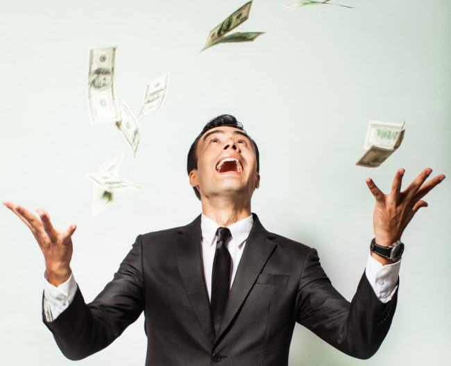 A happy man throwing cash up A man throwing cash up and smiling