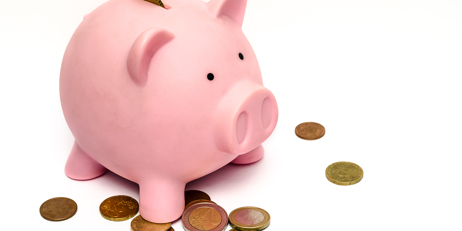 Coins fallen out of a pink piggy bank