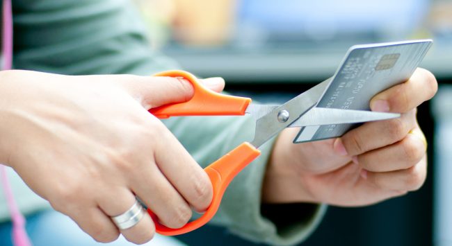 Hands of a lady cutting credit card