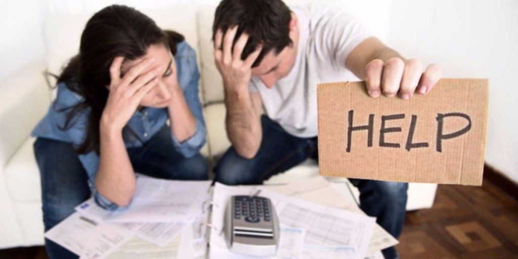A worried couple holding ply card labelled help