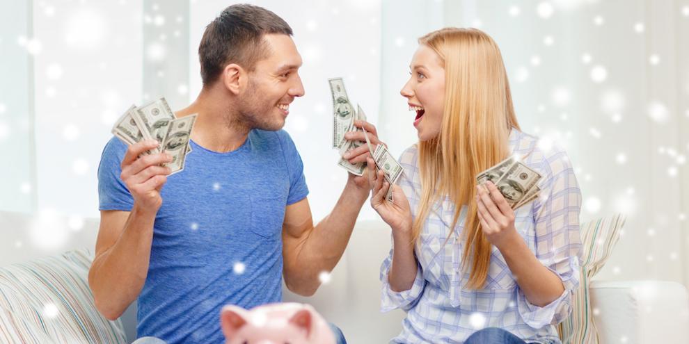 A happy couple holding cash in both hands