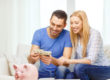 Smiling couple counting money at home