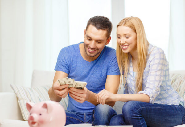 Smiling couple counting money at home Smiling couple counting money at home