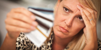 A lady staring her plastic cards A lady confused stare at her plastic cards