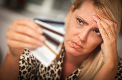 A lady staring her plastic cards A lady confused stare at her plastic cards