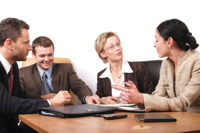 Four people during a meeting Two men and two women during a meeting
