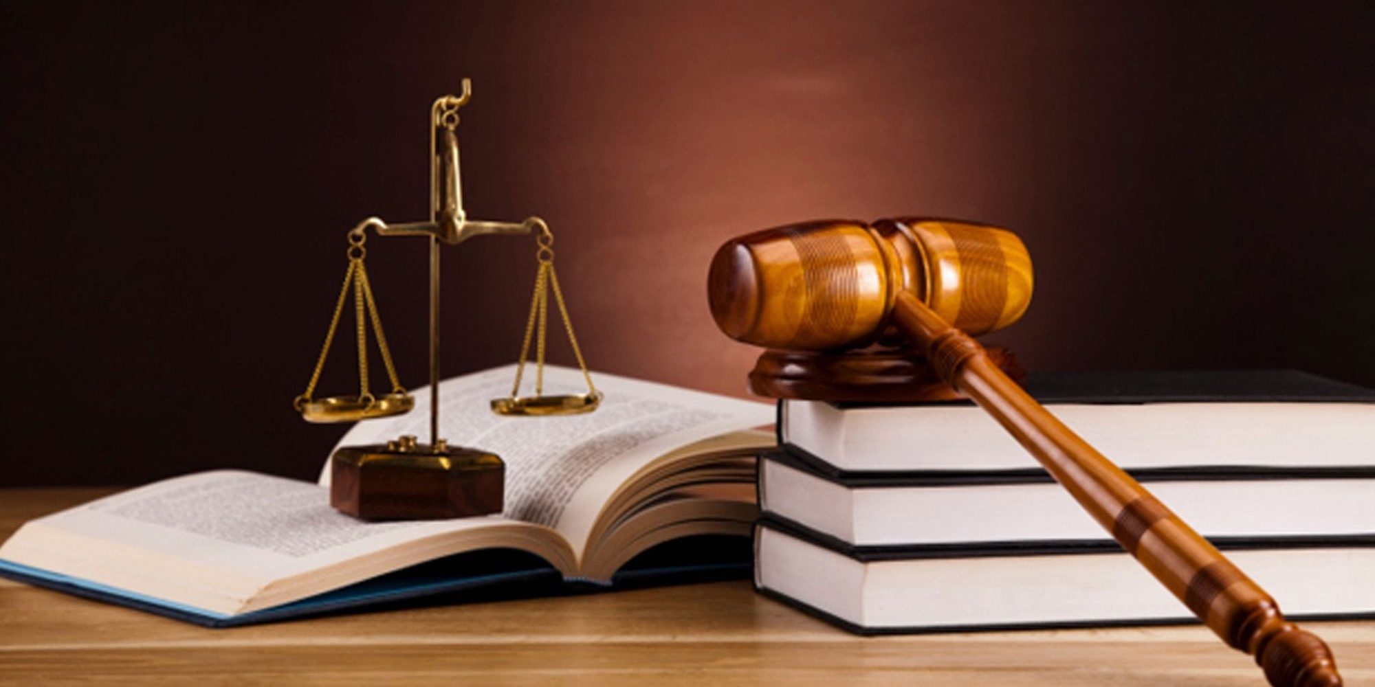 A beam balance and gavel placed on books over a table