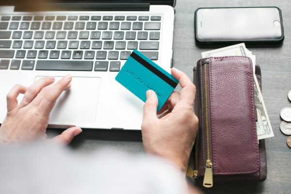 A hand on a laptop and other holding credit card A hand using laptop and other holding credit card