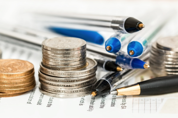 Coins and pens over a paper Some coins and pens placed over a paper